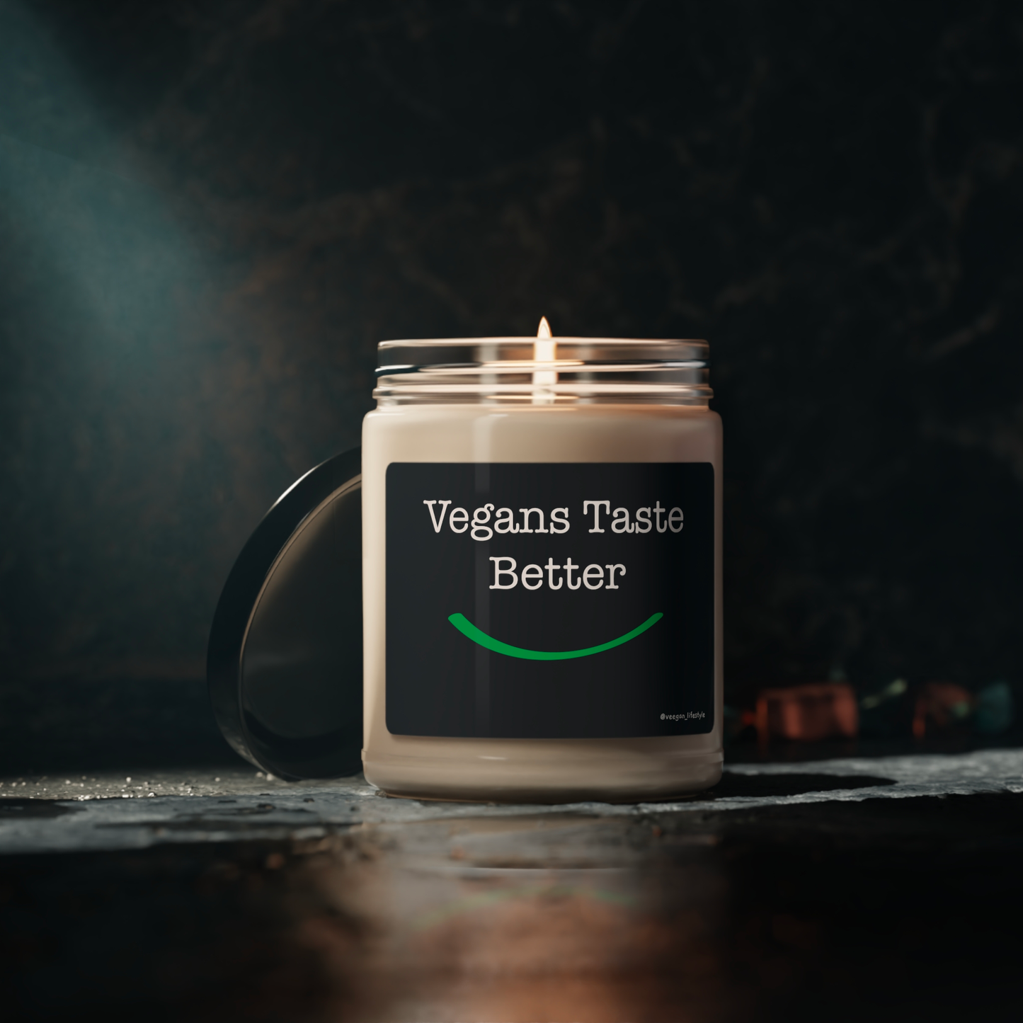 front view "Vegans Taste Better" scented candle in moody setting